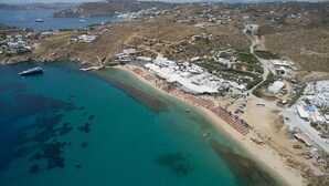 Vista aerea di una zona costiera con spiaggia, barche e edifici.