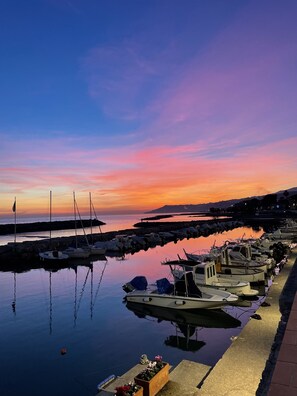 Ein Yachthafen mit angestaubten Booten im ruhigen Wasser bei Sonnenuntergang.
