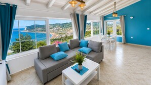 A spacious living area with a sofa, coffee table, and a view of the sea.