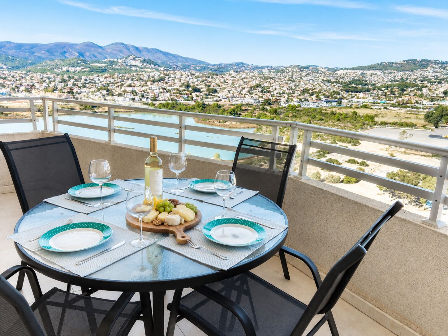 A round table with a view of a cityscape and mountains in the background.