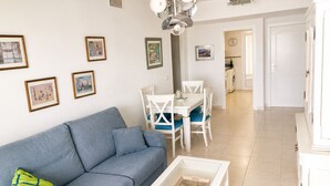 A living room with a sofa, a coffee table, and a dining area with chairs and a table. - New apartment with stunning views (Calpe)