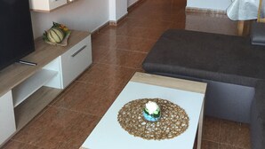 A modern living room with a TV, sofa, and coffee table.