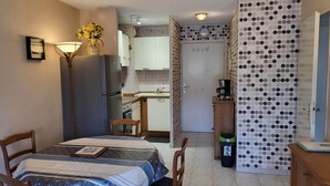 A compact kitchen with a refrigerator, sink, and a coffee maker on a small table. - Apartment T2 air-conditioned, Wifi Fibre, Garage, 4 people (Le Cannet)