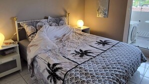 A bedroom with a bed, bedside tables, a ceiling fan, and a view of the outdoors. - Apartment T2 air-conditioned, Wifi Fibre, Garage, 4 people (Le Cannet)