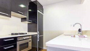 Una cocina moderna con horno empotrado, microondas y campana extractora de acero inoxidable.