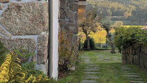 Ein Steingebäude mit einem Steinweg, der zu einem Weinberg führt.