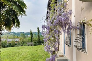 Surrounded by lush greenery, this serene setting offers a tranquil escape with a wisteria-draped balcony and scenic views.