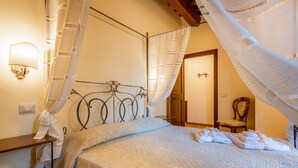 A bedroom with a bed, a nightstand, a chair, and a wall-mounted light fixture. - Suite Apartment with independent access (Città della Pieve)