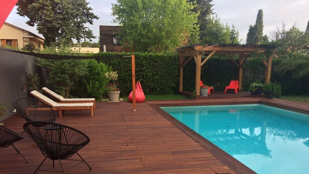 A wooden deck with a pool, lounge chairs, and a pergola. - Large & beautiful villa on large landscaped fenced garden, large secure pool. (Montpellier)