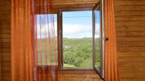 A room with wooden walls and a window with curtains. - Mountain Homes Gralheira - Mountain House (Cinfães)