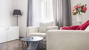 Ein modernes Wohnzimmer mit einer Couch, einem runden Couchtisch, einer Lampe und einer Vase mit Blumen.
