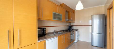 Una cocina moderna con armarios de madera, electrodomésticos de acero inoxidable y un horno empotrado.