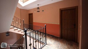 Un escalier avec une rampe métallique menant à un palier.