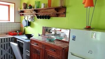 A kitchen with wooden cabinets, a white refrigerator, and a green wall.