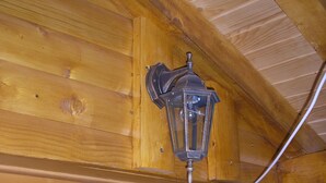 A wooden door with a glass panel and a wall-mounted light fixture.