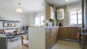 Una cucina moderna con mobili in legno, forno integrato e scaldabagno.
