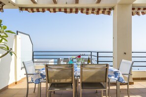Una terrassa amb taula per a dues persones, amb vista al mar.