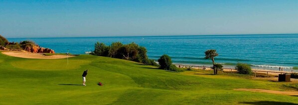 Ein Golfplatz mit Blick auf das Meer.