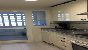 A kitchen with white cabinets, a black countertop, and a built-in oven. - Residencial Marina Duquesa 642 (Manilva)