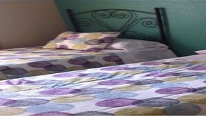 Two twin beds with a polka dot bedspread, a metal headboard, and a green wall. - Residencial Marina Duquesa 642 (Manilva)