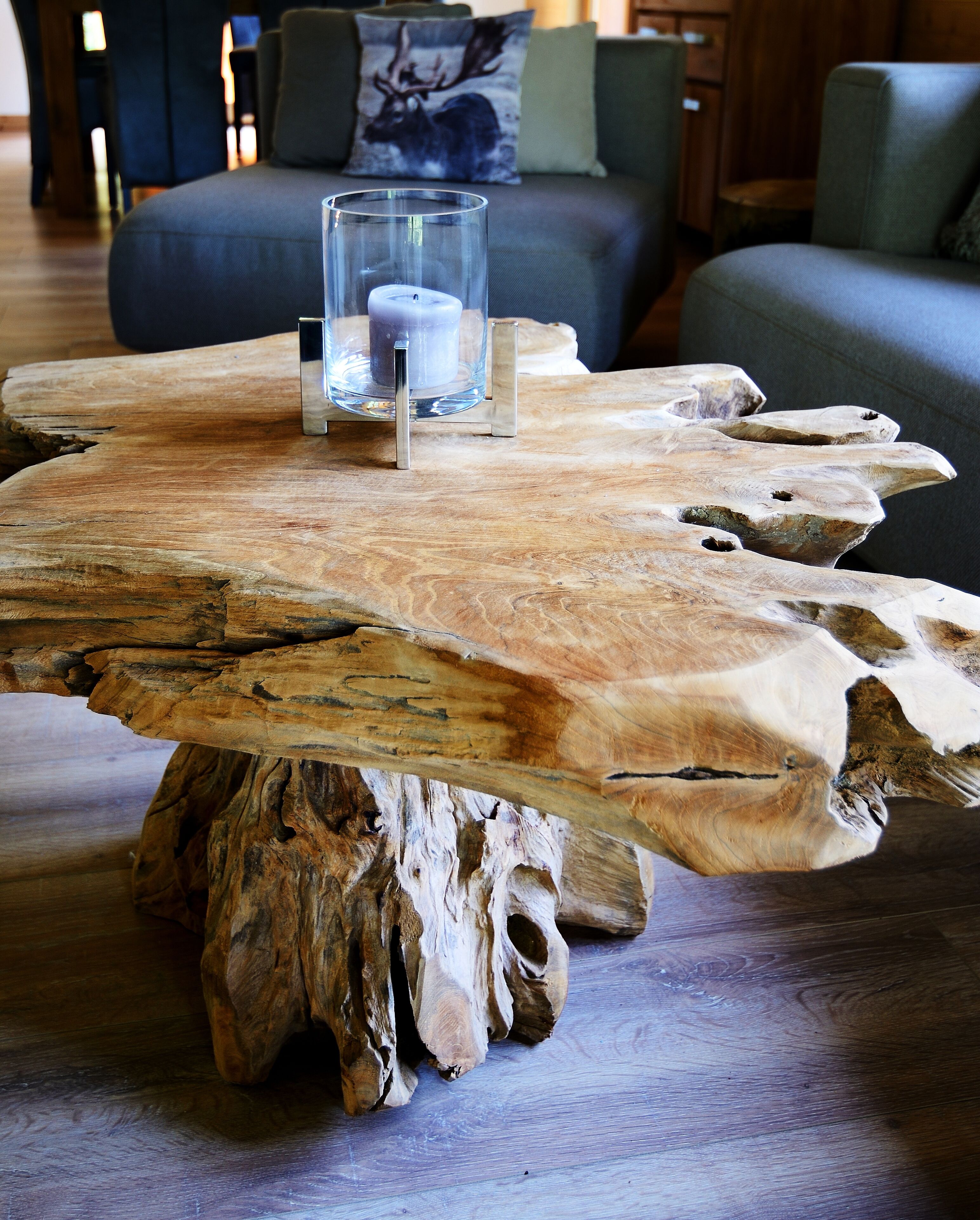 Una mesa de centro de madera rústica con un candelabro encima, sobre un piso de madera.