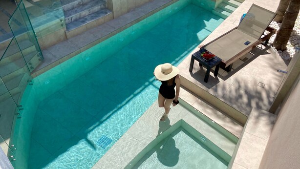 A pool area with clear water, a lounge chair, and a table with fruits. - Villa Kallergi - Athena (640 m2) - north-western Crete with Concert Piano & Pool (Rethymnon)