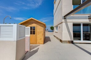 A modern building with a wooden cabin-like structure adjacent to a larger building with large windows. - New luxury villa, first line of the Mediterranean and the Mar Menor. (La Manga)