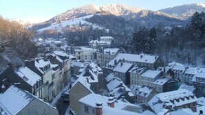 Un pueblo cubierto de nieve con edificios históricos y montañas al fondo.