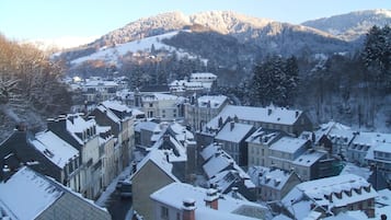 Une ville enneigée, avec des bâtiments historiques et un paysage montagneux en toile de fond.