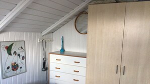 Ein Schlafzimmer mit zwei Betten, einem Holzschrank, einem Schminktisch und einem Wandbild.