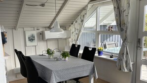 Ein Essbereich mit Tisch, Stühlen und Deckenventilator.