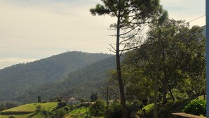 A wooden table and chairs on a grassy lawn with a mountain backdrop. - Rural apartment Casona la Sierra for 4 people (Cudillero)