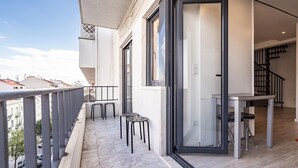 A balcony with a marble floor, a table, and two chairs.