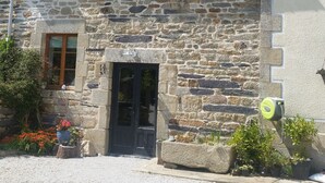 A stone building with a dark roof, a small balcony, and a door. - Beautiful, spacious, 2 bed renovated breton cider press, 10km from the coast! (Cast)