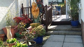 A narrow pathway with potted plants and a statue. - Fantastic self-catering apartment on the outskirts of Caerleon (Caerleon)