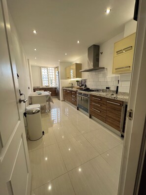 Cocina moderna con una isla central, electrodomésticos integrados y vistas al comedor.