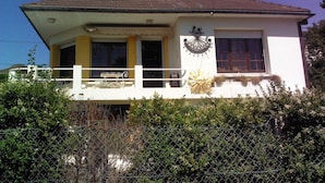 A two-story building with a balcony, a sun dial, and a small window with a decorative frame. - 2 ROOMS FOR RENT TWO STEPS FROM THE SEA (Ault)