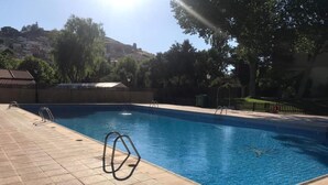 En swimmingpool med ett kaklat poolområde, en stege och en livboj.