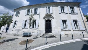 A historic building with a central entrance, multiple windows, and a symmetrical facade.