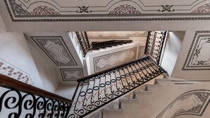 A grand staircase with ornate metal railings and detailed wall decorations. - fully frescoed home in Sardinia (Quartu Sant'Elena)