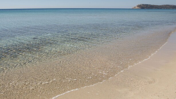 A beach with clear shallow waters and a sandy shore. - fully frescoed home in Sardinia (Quartu Sant'Elena)