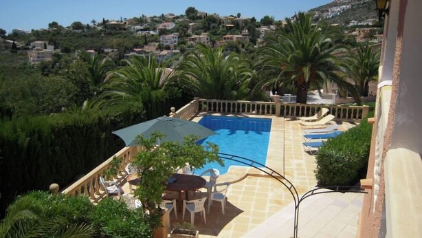 Una piscina sul tetto con vista su una cittadina collinare.