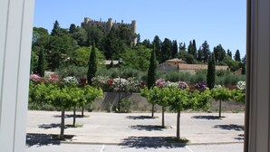 Un parking bordé d’arbres, avec un château en arrière-plan.