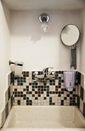 A bathroom with a tiled backsplash, a sink, a toilet paper holder, a soap dispenser, and a mirror. - Tourist accommodation in the heart of Salento - Gallipoli Maldive del Salento Ugento (Casarano)