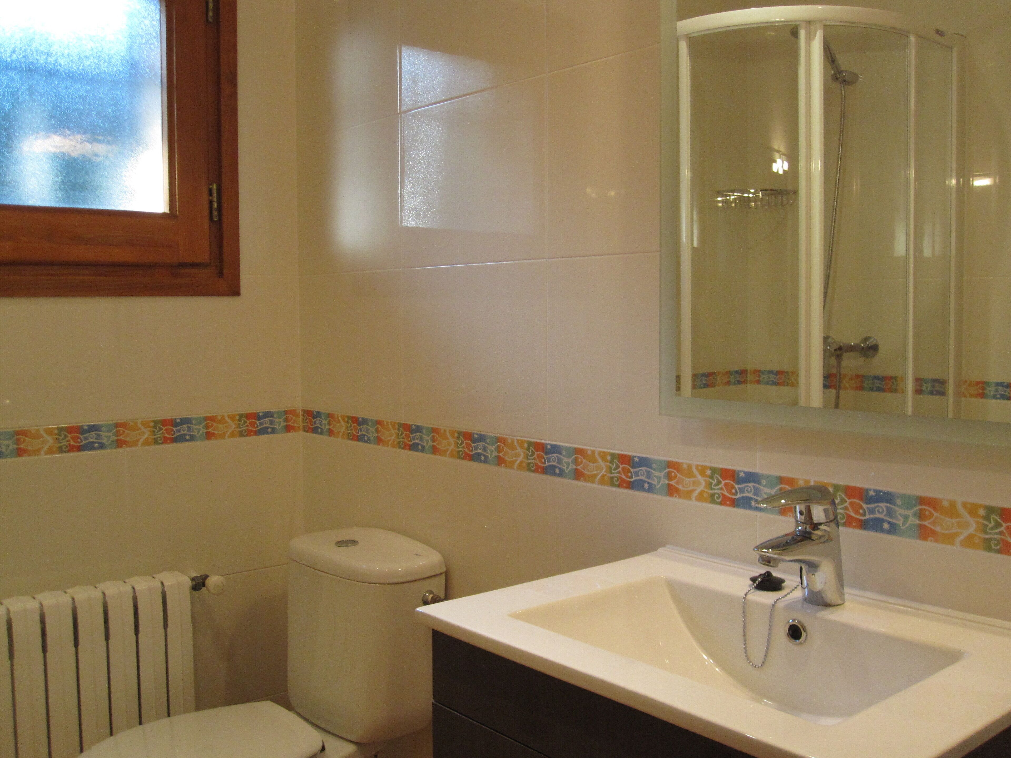 Une salle de bain avec des toilettes, un lavabo et une douche.