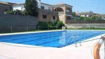 Relax by the pool surrounded by a spacious deck and scenic views of traditional buildings.