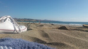 A beach with a pair of white sneakers on the sand, a clear blue sky, and distant mountains. - Costa Calma Penthause. Wonderful penthouse On one of the best beaches in Europe (Pájara)