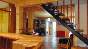 A spacious room with a wooden bench, a red cabinet, and a staircase.
