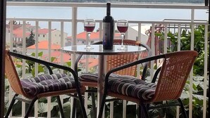 A balcony with a round table, two wicker chairs, and two wine glasses. - 3 room apartment - cozy and modern (Trogir)