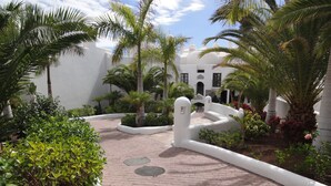 A paved pathway leading to a white building with domed architecture, surrounded by palm trees and greenery. - Luxury Bungalow Costa Adeje; Heated Pool, Air Conditioner, WiFi & Parking free (Adeje)